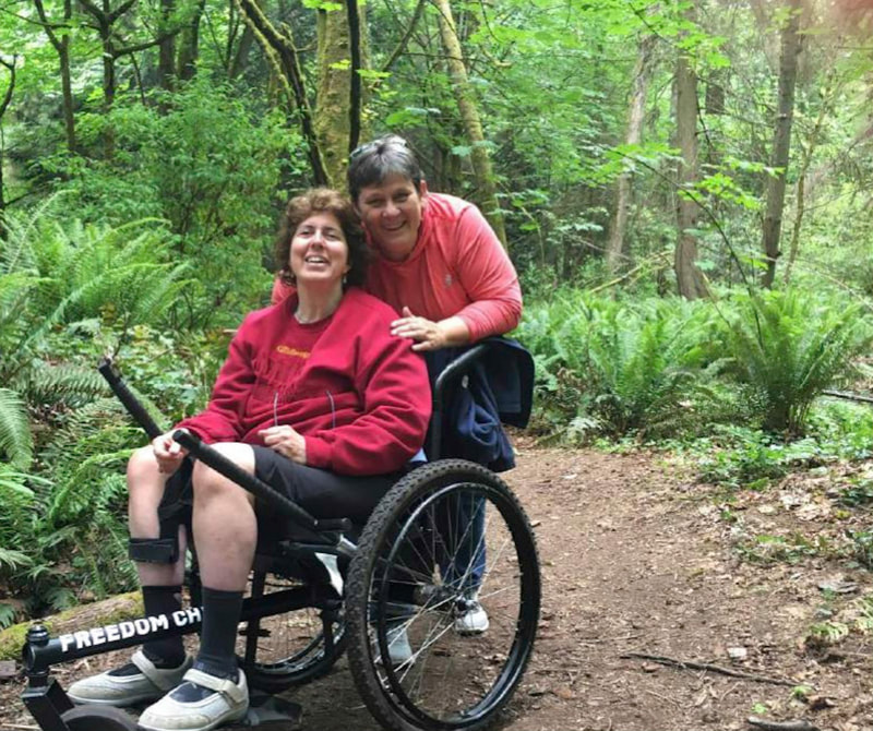 Person using the all terrain wheelchair with a friend.